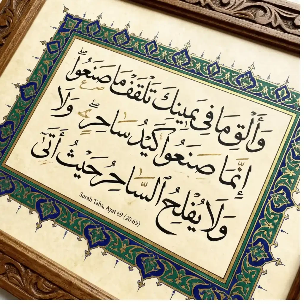 Close-up photograph of a framed piece of Islamic calligraphy. It features intricate Arabic script from Surah Taha, Ayat 69 (20:69) in a traditional illuminated border with green, blue, and gold motifs on aged parchment-like paper, held in a dark carved wooden frame.