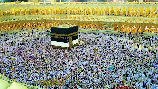 Aerial view of millions of Muslim pilgrims in white garments performing Tawaf around the Holy Kaaba inside the illuminated Masjid al-Haram in Mecca, Saudi Arabia.